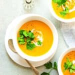 Vegan Roasted Carrot Soup garnished with cilantro and coconut cream