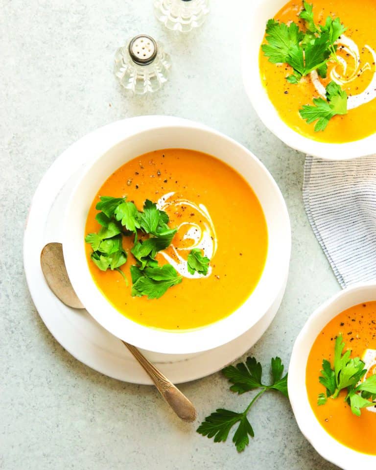 Vegan Roasted Carrot Soup garnished with cilantro and coconut cream